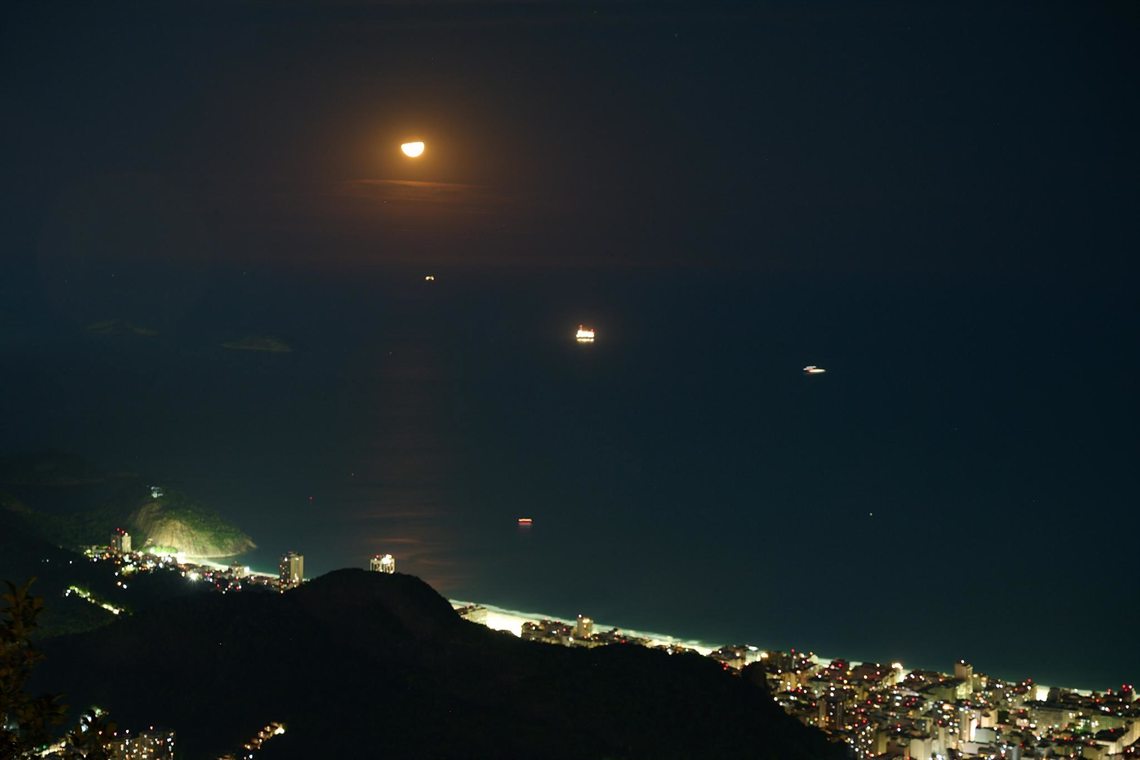 Vista aérea noturna do Rio de Janeiro com o Cristo iluminado
